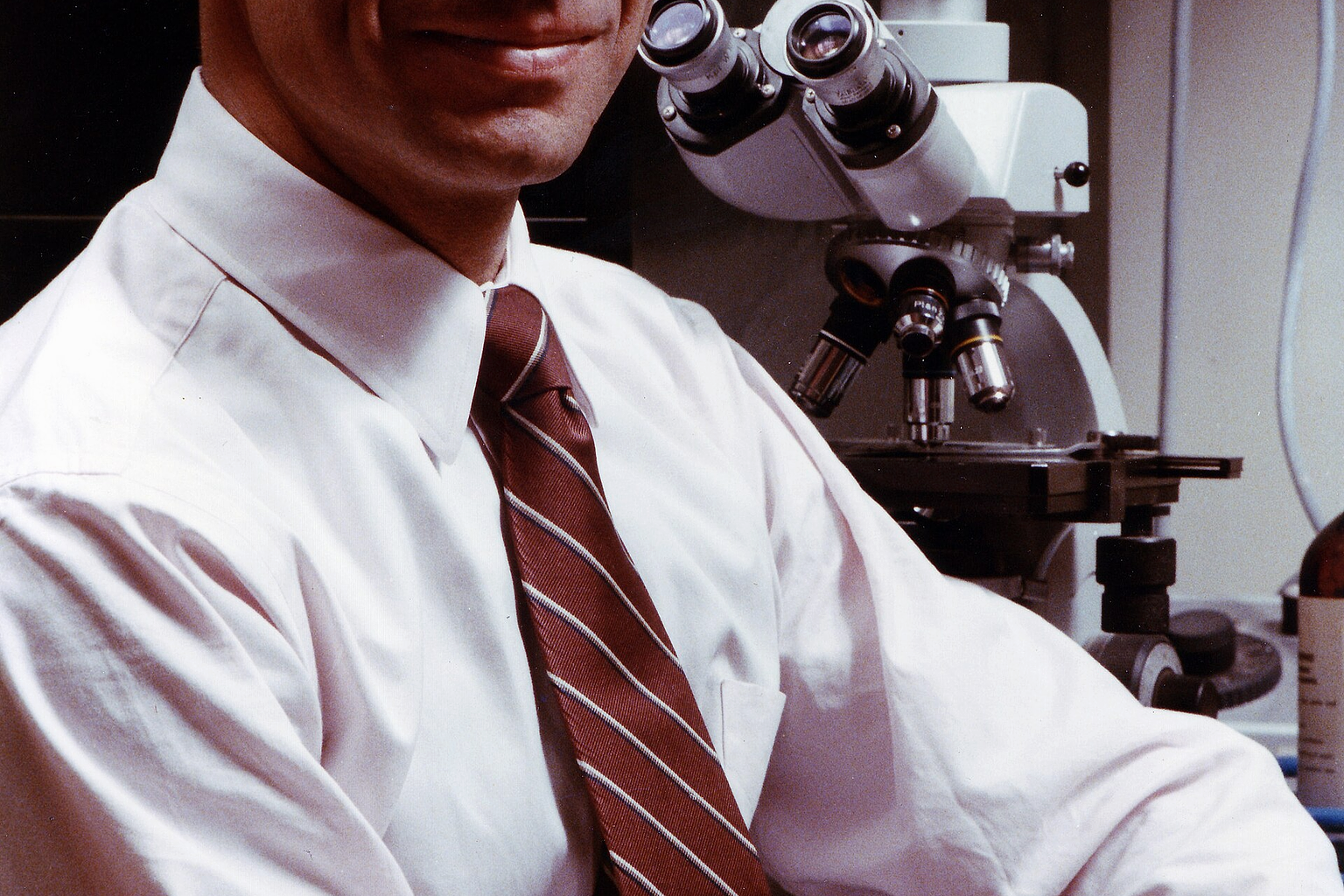 Dr. Anthony Fauci in front of a microscope, 1984. Credit: NIAID