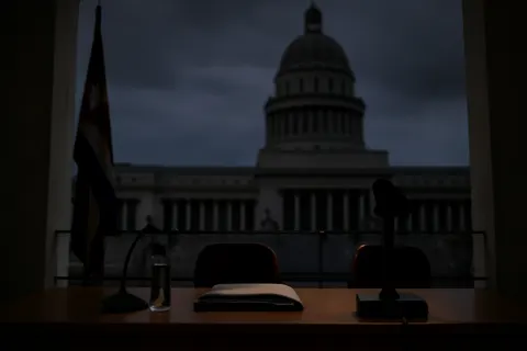 Grounded editorial scene illustrating The Caribbean island faces its third nationwide power outage in six months, with authorities citing fuel restrictions and an aging grid as key factors.