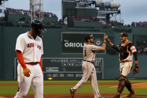 Grounded editorial scene illustrating After starting July last in the AL East, the Boston Red Sox surged with a 15-game winning streak, transforming into a strong postseason contender before the streak ended.