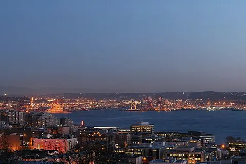Seattle Skyline view from Queen Anne Hill. The Space Needle is visible on the left, the mountain in the background is Mount Rainier , on the right is the Port of Seattle on Puget Sound.