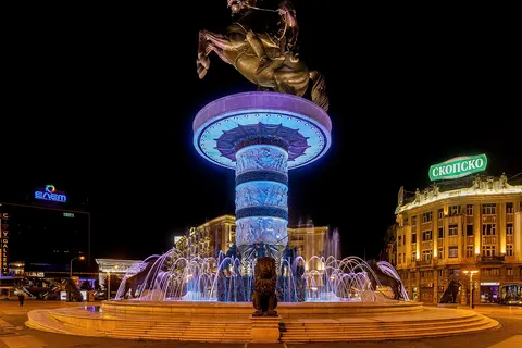 The Warrior on a Horse statue is one of the main symbols of the Skopje 2014 project and is located in the center of Macedonia Square in Skopje , capital of the Republic of Macedonia . Although it is not officially named for him, it is typically thought to depict Alexander the Great . The statue was sculpted by Valentina Stefanovska and completed on September 8, 2011 to commemorate 20 years of the independence of the Republic of Macedonia . The bronze sculpture is 14.5 m tall and it sits on a cylindrical column, which itself is 10 m in height. The column consists of three large ivory sections containing reliefs, each separated by a thinner bronze ring. Each section contains reliefs. The column stands in a fountain and at the base of the column there are 8 bronze soldiers, each 3 m tall and 8 bronze lions, each 2.5 m tall.
