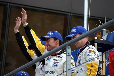 Oliver Gavin, Olivier Bereta & Jan Magnussen celebrate their GTS class win on the podium at the 2004 Le Mans