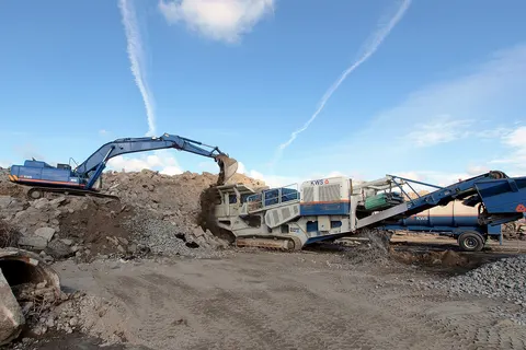 KWS crane feeding the Kleemann stone crusher.