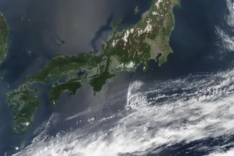 Satellite image of Japan in May 2003. The islands of Japan are shown clearly off the coast of North and South Korea, China, and Russia in this true-color image. Running down through the islands are a string of mountains that make up part of the Pacific "Ring of Fire." The Ring of Fire is a zone of frequent earthquakes and volcanic eruptions that stretches in a series of arcs from New Zealand, through Indonesia, up through the Philippines, Japan, the Kuril Islands and Kamchatka Peninsula (Russia), across the Pacific Ocean via the Aleutian Islands, and down the coast of the Americas. Seventy-five percent of the world's volcanoes are in this ring, making it the most volcanically-active region on the planet. Also shown in this image are a number of fires, which are marked with red dots. A few fires were detected in Japan, China, and North Korea, but the majority were detected in Russia's Primorskiy-Kray region. This true-color Aqua MODIS image was acquired on May 1, 2003.