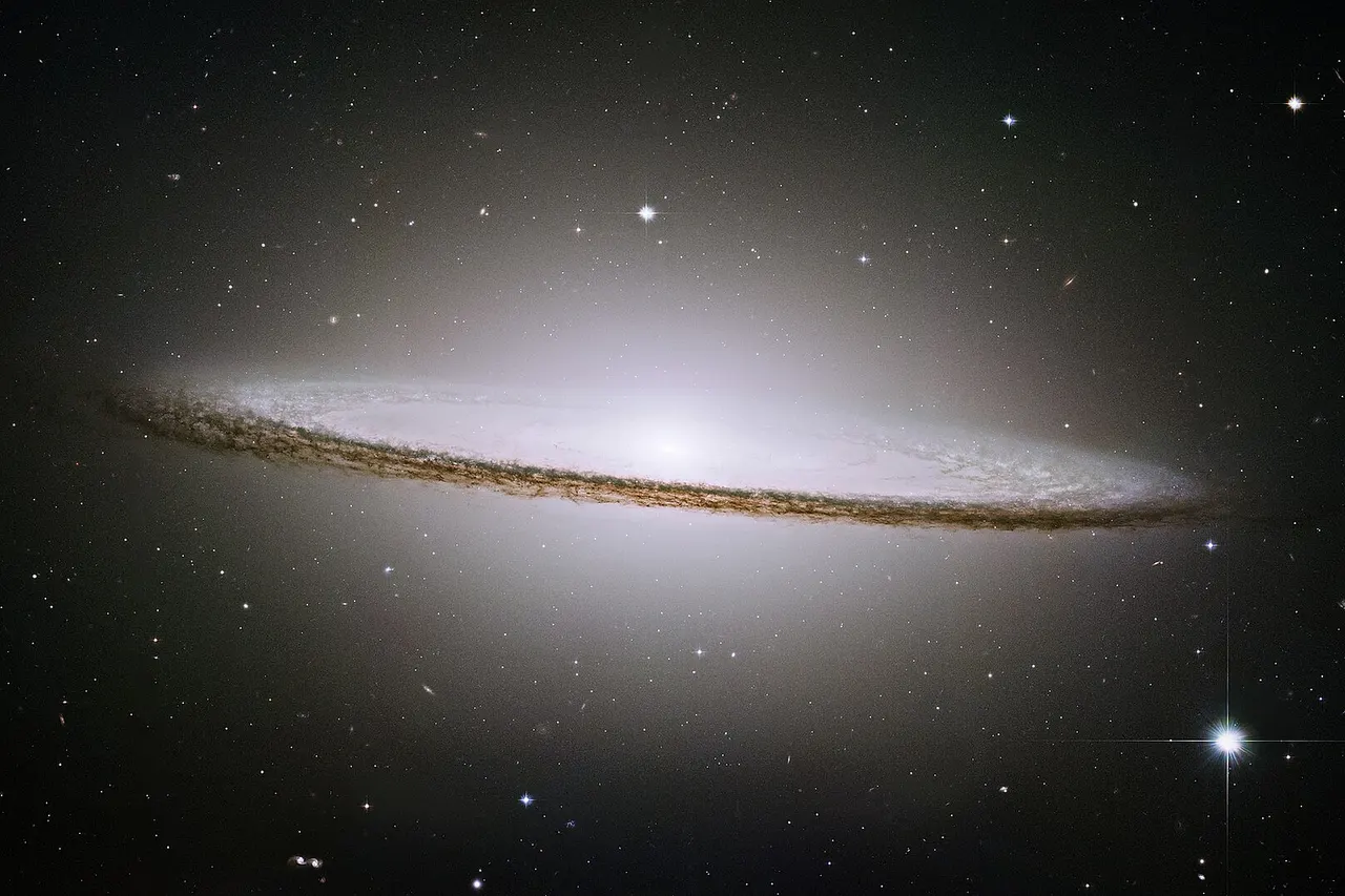 The famous Sombrero galaxy (M104) is a bright nearby elliptical galaxy. The prominent dust lane and halo of stars and globular clusters give this galaxy its name. Something very energetic is going on in the Sombrero's center, as much X-ray light has been detected from it. This X-ray emission coupled with unusually high central stellar velocities cause many astronomers to speculate that a black hole lies at the Sombrero's center - a black hole a billion times the mass of our Sun.