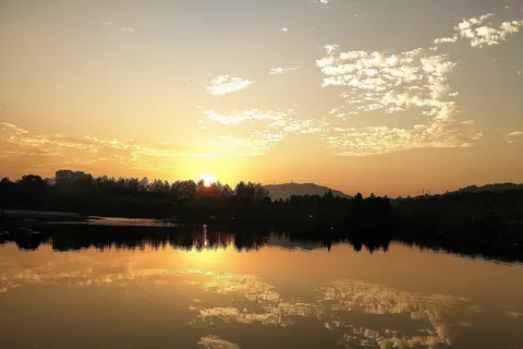 ​浙江农林大学东湖在黄昏时的照片，夕阳几乎完全沉入地平线下。