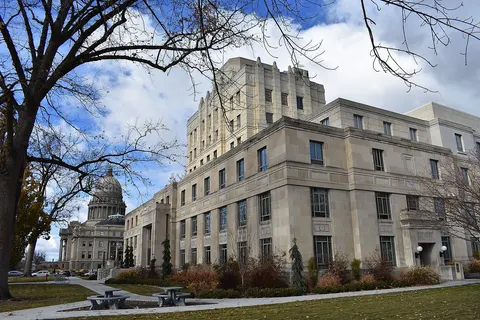At right are the West Jefferson Street and North 5th Street exposures of the Old Ada County Courthouse (1939), designed by Tourtellotte & Hummel and Wayland & Fennell, and in the distance is the Idaho State Capitol Building (1912 and 1920), designed by Tourtellotte & Hummel. The buildings are part of the Boise Capitol Area District and listed on the National Register of Historic Places.