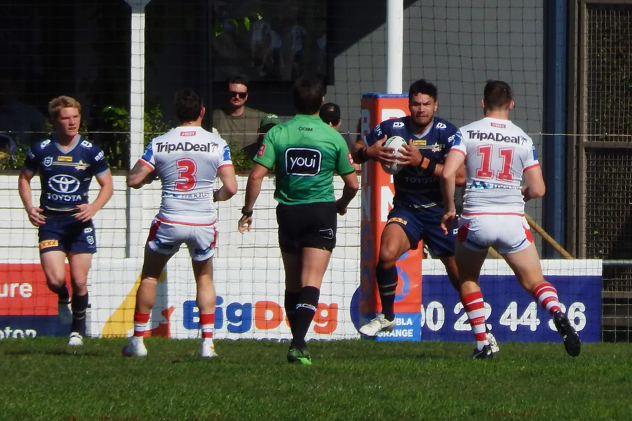 St George Illawarra Dragons and North Queensland Cowboys players competing in the second NRL game to be played in the regional Australian city of Rockhampton, Queensland on 28 August 2021. The North Queensland Cowboys won the match 38-26. The game attracted a crowd of 4,487. The Round 24 game was the second of two NRL games played in Rockhampton over two consecutive weeks with the attendance boosted by the presence of a Queensland-based team. (1,624 more people attended the second game compared to the previous week's game at Browne Park between Wests Tigers and Cronulla Sharks.)