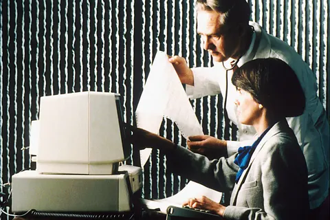 Title Doctor and Librarian Working with PDQ Description A female librarian seated at a computer working with PDQ, while a male physician examines a print-out. Topics/Categories People -- Health Professional Type Color, Photo Source National Cancer Institute