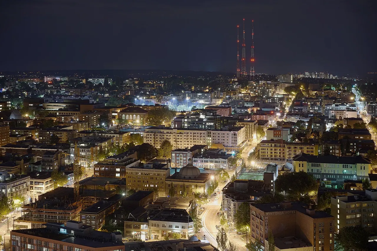 Night photo of Capitol Hill, Seattle as seen from the top floor of Premiere on Pine , a high rise residential building. In the distance on the horizon is Bellevue .
