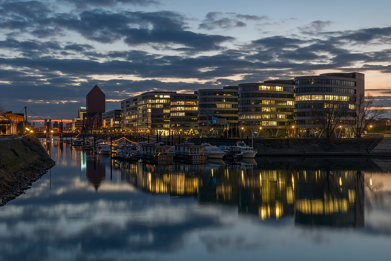 Nightly view of Duisburg Inner Harbour with office building "Five Boats" and marina