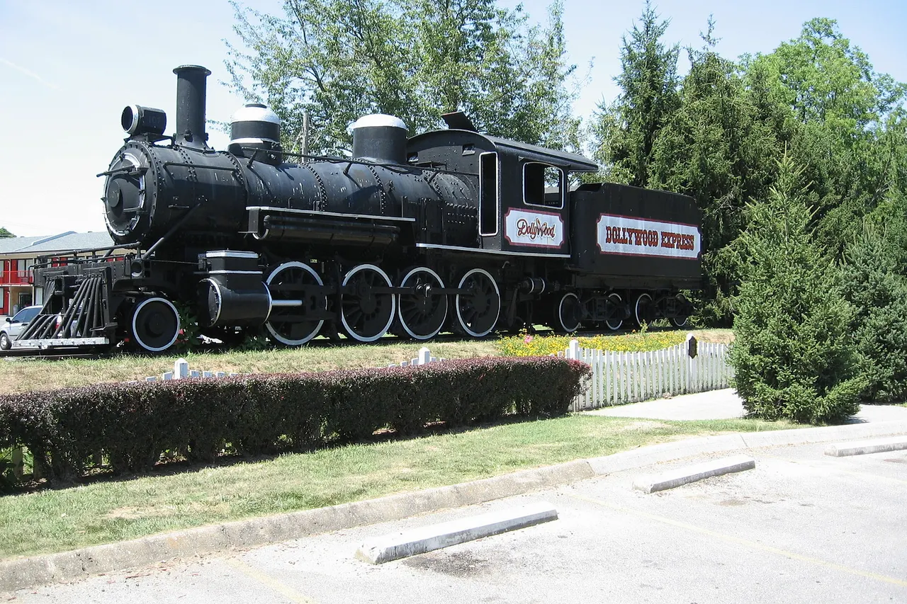 This is a photo of a 2-8-0 steam engine built by Baldwin Locomotive Works as construction number 8869. It became Smoky Mountain Railroad engine #107 and was later owned by Rebel Railroad. It is now owned by the Dollywood themepark and is on display at Hwy 441 in Pigeon Forge, TN.