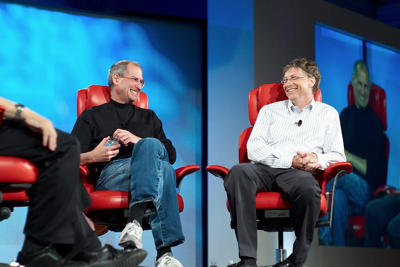 Walter Mossberg and Kara Swisher interview Steve Jobs and Bill Gates at 'D5: All Things Digital' conference in Carlsbad, California, in 2007. Quotes made during the time of the photograph. [1] Kara: "What you think each has contributed to the computer and technology industry, starting with you, Steve, for Bill, and vice versa." Steve: "Bill built the first software company in the industry and I think he built the first software company before anybody really in our industry knew what a software company was, except for these guys. And that was huge. That was really huge. And the business model that they ended up pursuing turned out to be the one that worked really well, you know, for the industry. I think the biggest thing was, Bill was really focused on software before almost anybody else had a clue that it was really the software." Walt: "Bill, how about the contribution of Steve and Apple?" Bill: "Well, first, I want to clarify: I’m not Fake Steve Jobs . [Peals of laughter.] What Steve’s done is quite phenomenal, and if you look back to 1977, that Apple II computer, the idea that it would be a mass-market machine, you know, the bet that was made there by Apple uniquely—there were other people with products, but the idea that this could be an incredible empowering phenomenon, Apple pursued that dream. Then one of the most fun things we did was the Macintosh and that was so risky. People may not remember that Apple really bet the company. Lisa hadn’t done that well, and some people were saying that general approach wasn’t good, but the team that Steve built even within the company to pursue that, even some days it felt a little ahead of its time—I don’t know if you remember that Twiggy disk drive and…"