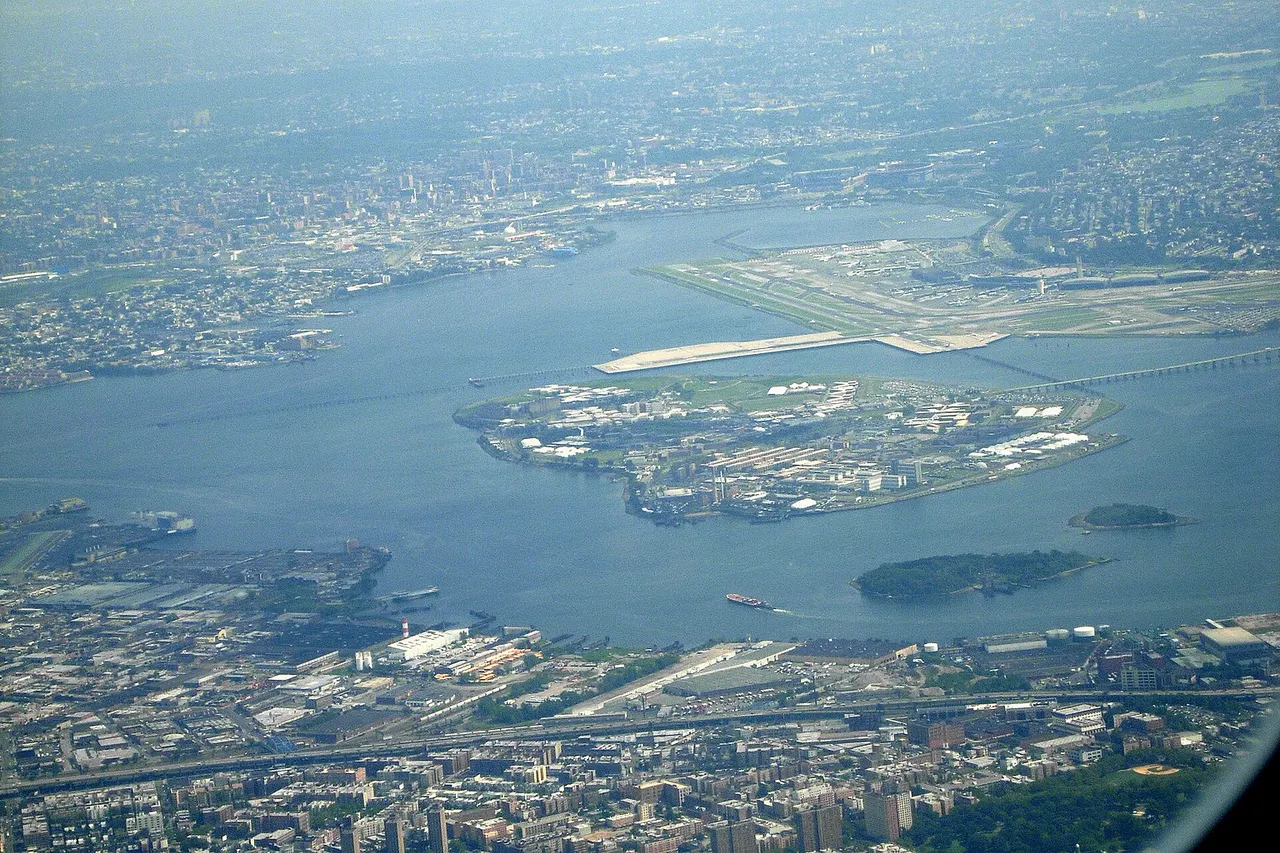 A view of Rikers Island in New York, United States, looking south from the air over The Bronx. LaGuardia Airport can be seen in the background. Flushing Bay, Shea Stadium and Citi Field can be seen slightly behind LaGuardia. Vernon C. Bain Correctional Center can be seen in the lower left as the blue and white docked prison barge. The Hunts Point Wastewater Treatment Plant is located to the right of the Bain Correctional Center.