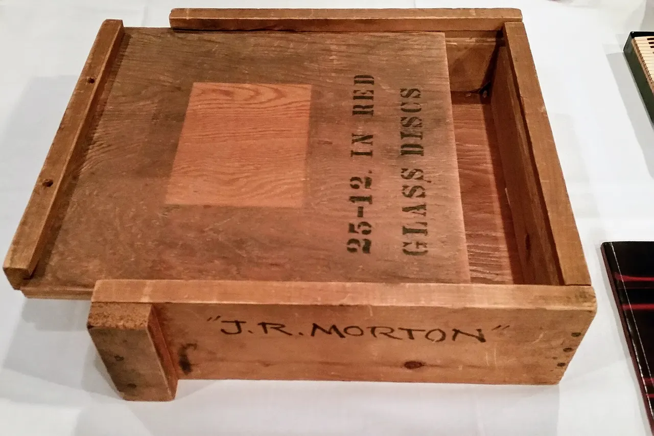 The crate in this photograph is the property of, and presumed to have been created by, the United States Library of Congress . This crate housed glass discs copied from Alan Lomax's original recordings of Jelly Roll Morton (see en:The Complete Library of Congress Recordings ). Lomax's original discs were made of acetate and aluminum. When the Library made copies of these during World War II, aluminum was in short supply due to the war effort, and they used glass discs instead. Due to their fragility, these glass discs were stored in wooden crates including the one in this photograph.